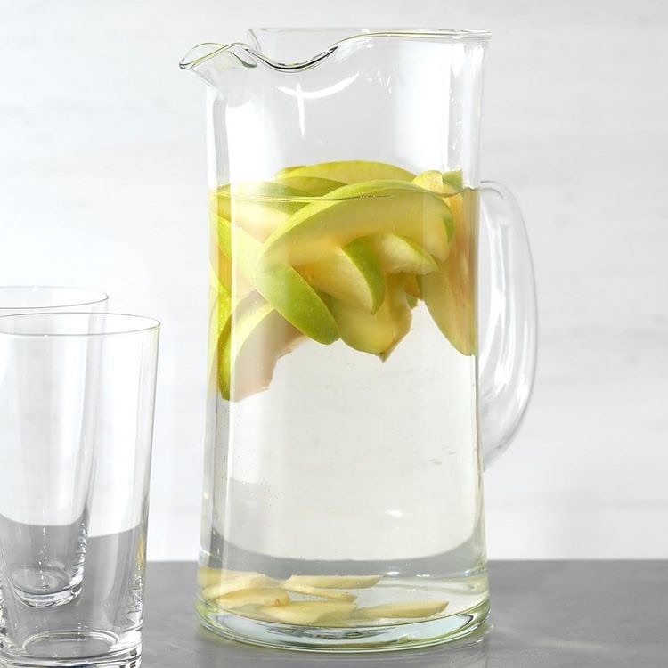 Pitcher with apple-infused water and glasses