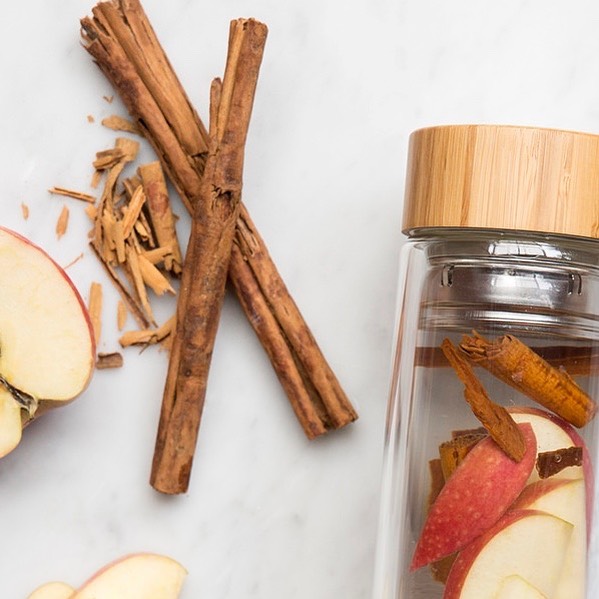 Cinnamon sticks and apples with glass jar.