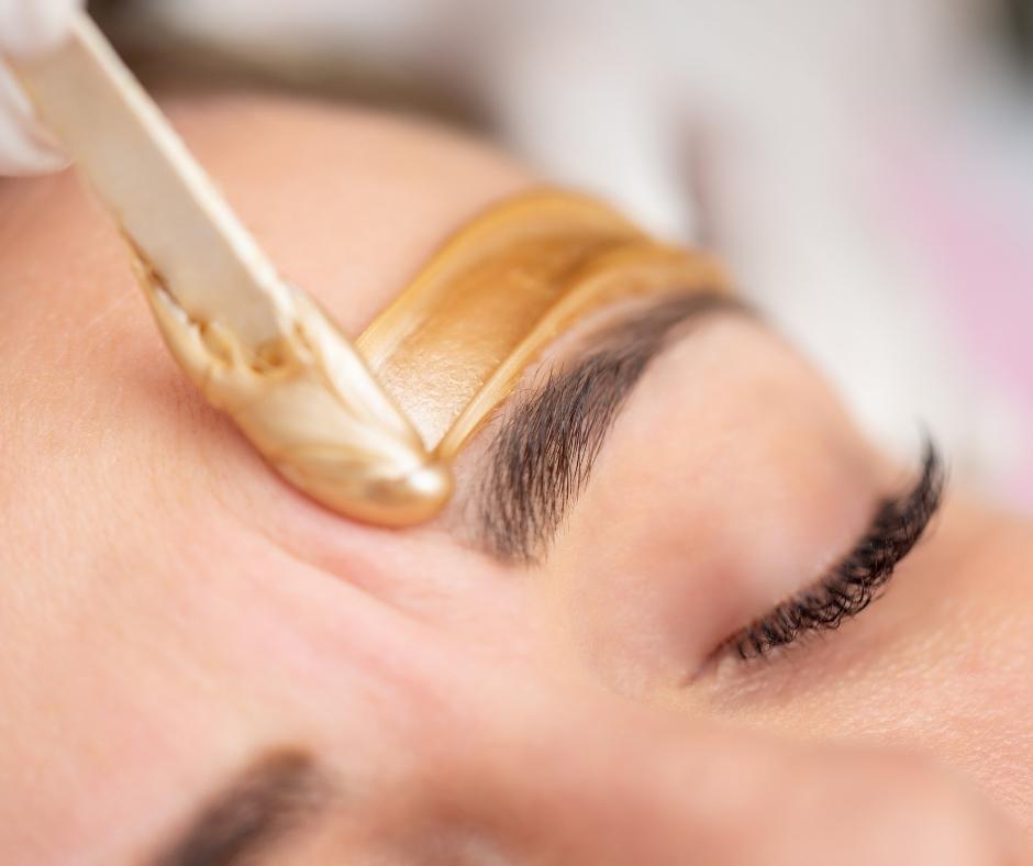 A woman getting her eye brows waxed