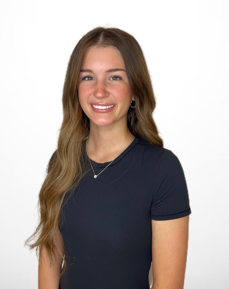 Smiling person with long hair wearing a black shirt.